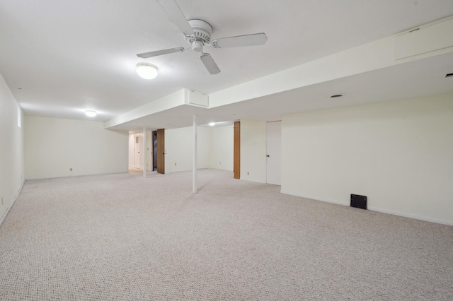 finished basement with a ceiling fan and light carpet