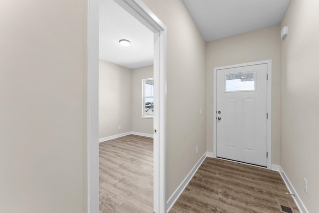 interior space with visible vents, baseboards, and wood finished floors