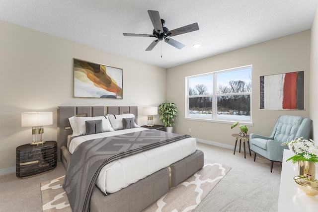 carpeted bedroom featuring ceiling fan, a textured ceiling, and baseboards