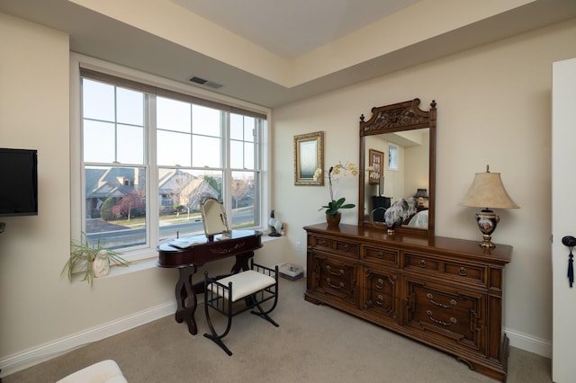 living area with baseboards, visible vents, and light carpet