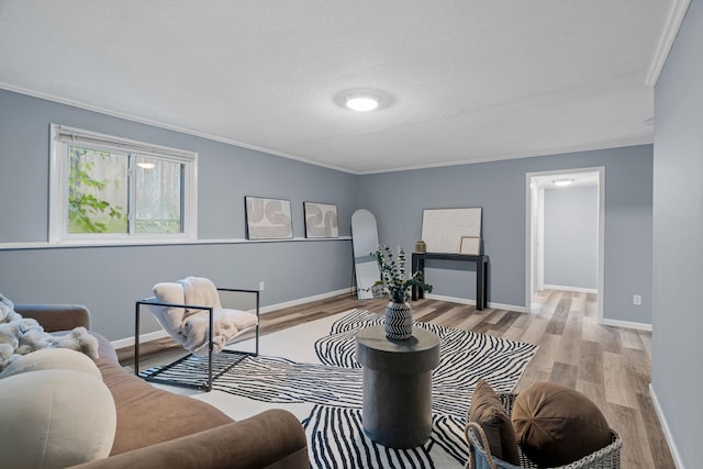 living area with baseboards, a textured ceiling, wood finished floors, and crown molding