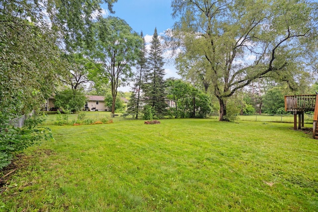 view of yard featuring a wooden deck and fence