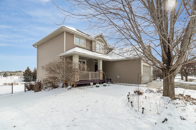 view of front of house featuring a porch, fence, and a garage