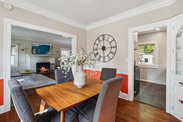 5026 Nokomis Ave, Minneapolis, MN 55417 - dining space with ornamental molding, a brick fireplace, baseboards, and dark wood-type flooring