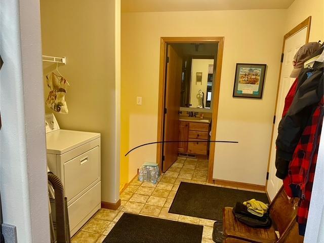 washroom featuring light tile patterned floors, laundry area, washer / clothes dryer, and baseboards