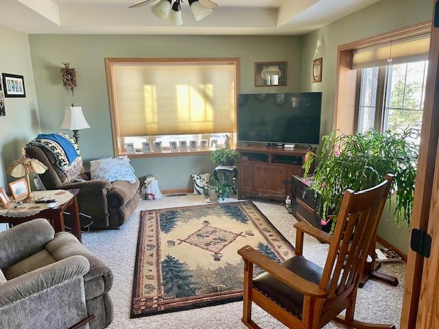 carpeted living room featuring a ceiling fan