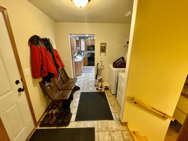 interior space featuring baseboards, visible vents, and washer and clothes dryer