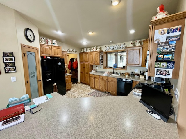 kitchen featuring light floors, a peninsula, a sink, black appliances, and light countertops