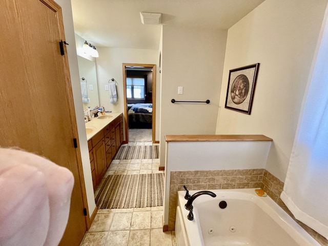 bathroom with tile patterned floors, connected bathroom, a tub with jets, and double vanity