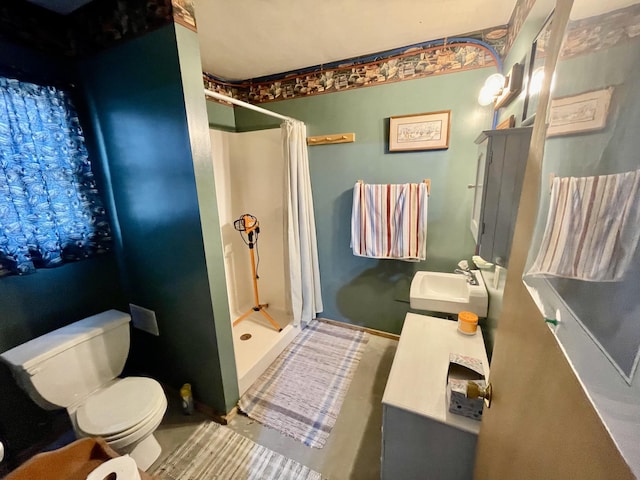 bathroom with a shower stall, toilet, and a sink