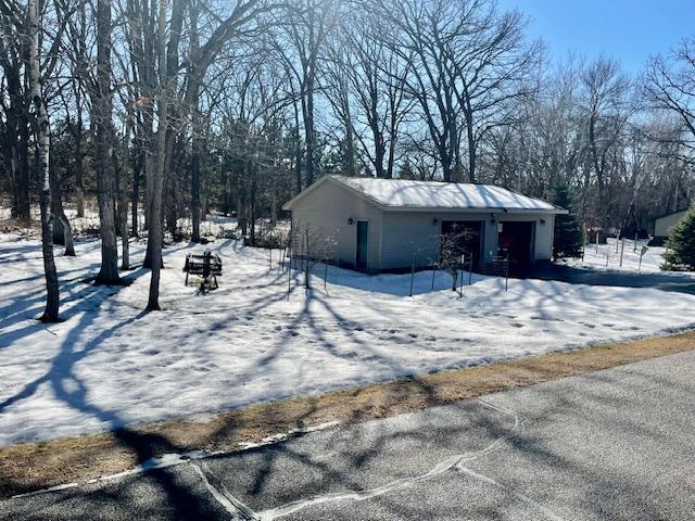 snow covered property with an outdoor structure