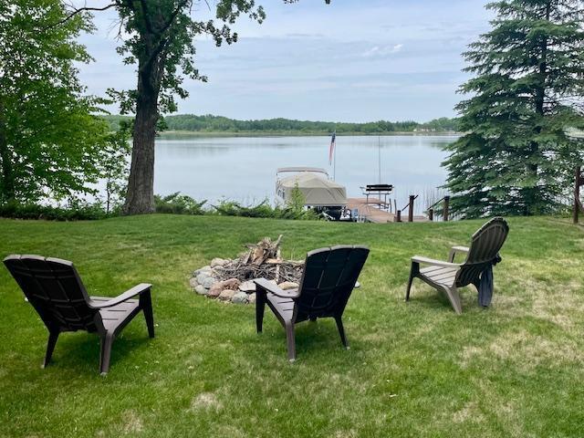 26909 Lake Ethel Rd, Girard Twp, MN 56515 - view of green lawn featuring an outdoor fire pit, a boat dock, and a water view