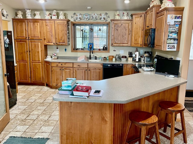 26909 Lake Ethel Rd, Girard Twp, MN 56515 - kitchen with black appliances, light countertops, a sink, a peninsula, and a breakfast bar