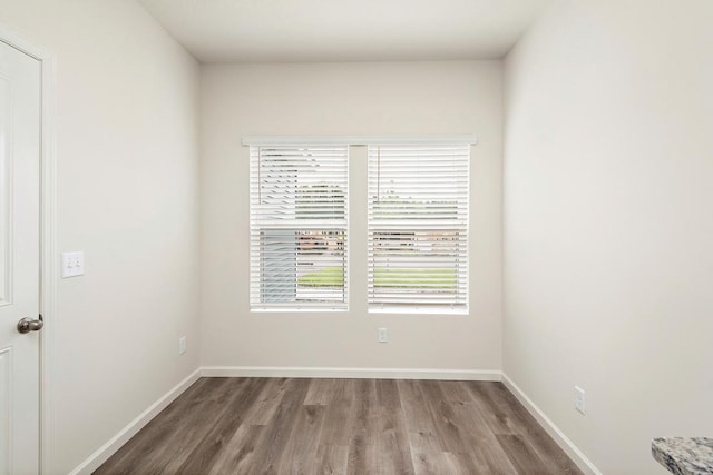 unfurnished room with baseboards and wood finished floors