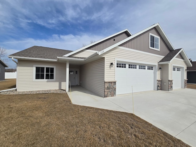 view of front of property featuring stone siding, driveway, an attached garage, and a shingled roof