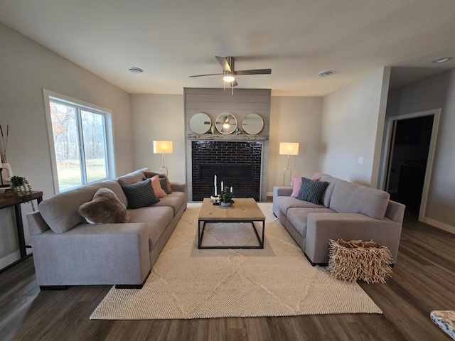 living room featuring visible vents, baseboards, a tile fireplace, wood finished floors, and a ceiling fan