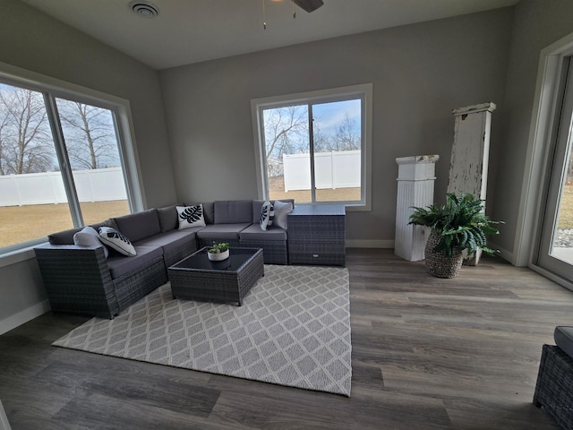 living area featuring visible vents, baseboards, wood finished floors, and a ceiling fan