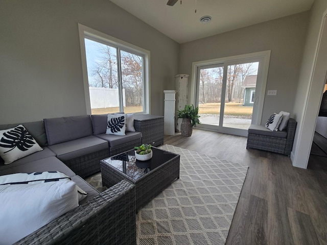 living room featuring lofted ceiling, wood finished floors, and a ceiling fan