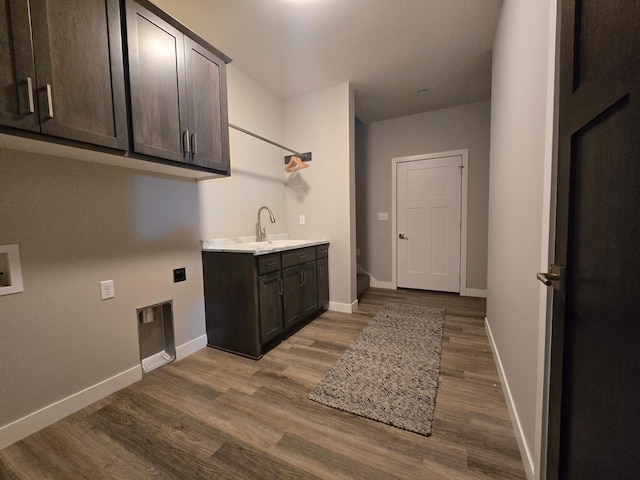 clothes washing area with dark wood finished floors, cabinet space, hookup for an electric dryer, and baseboards