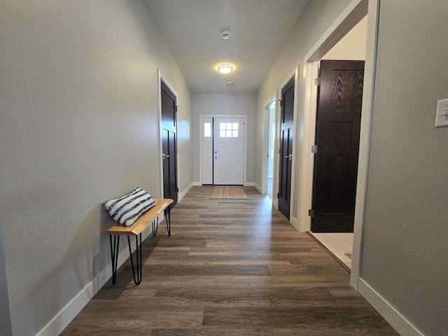 hall with dark wood-type flooring and baseboards