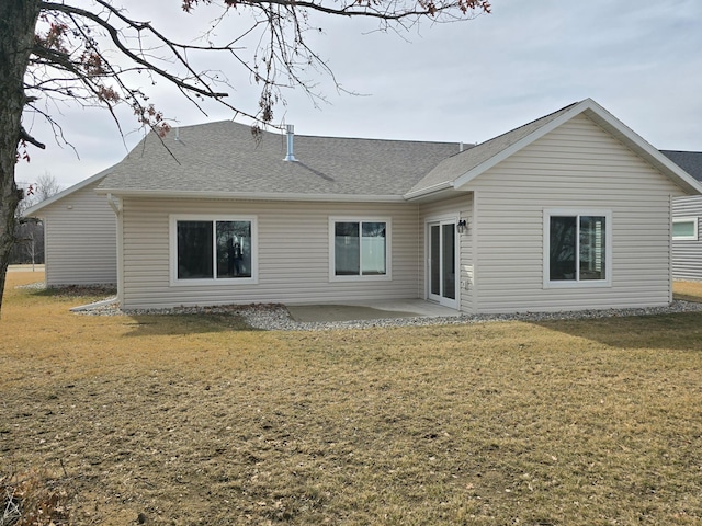 rear view of house featuring a yard, a patio area, and a shingled roof