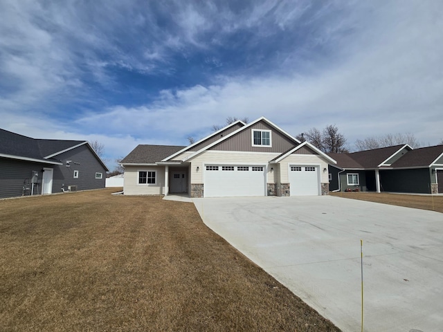 craftsman house featuring a garage, stone siding, a front lawn, and driveway