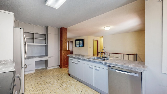 kitchen featuring a sink, a textured ceiling, and stainless steel appliances