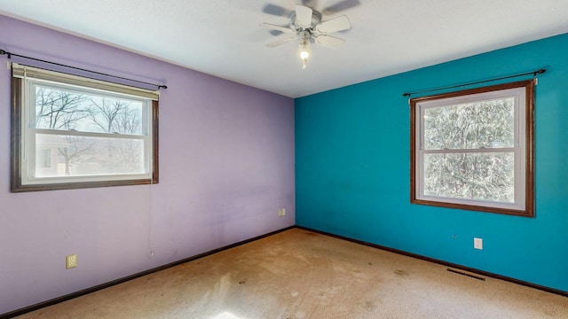 unfurnished room with a ceiling fan, carpet, visible vents, and baseboards