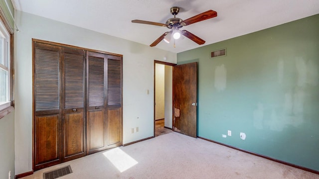 unfurnished bedroom featuring visible vents, baseboards, light colored carpet, and a closet