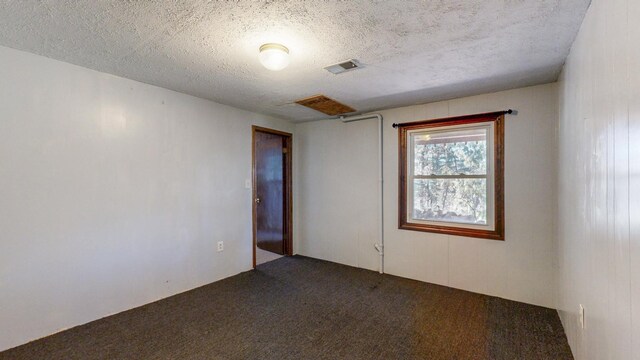 carpeted empty room with visible vents and a textured ceiling