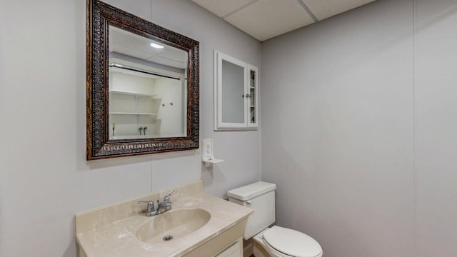 bathroom with vanity, toilet, and a paneled ceiling