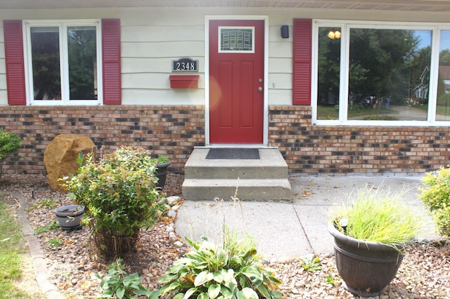 doorway to property with brick siding