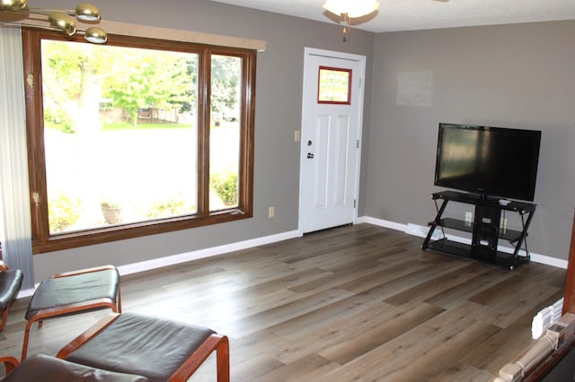 interior space with plenty of natural light, wood finished floors, baseboards, and ceiling fan