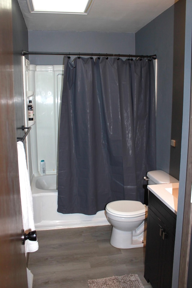 bathroom featuring vanity, toilet, wood finished floors, and shower / bath combo with shower curtain