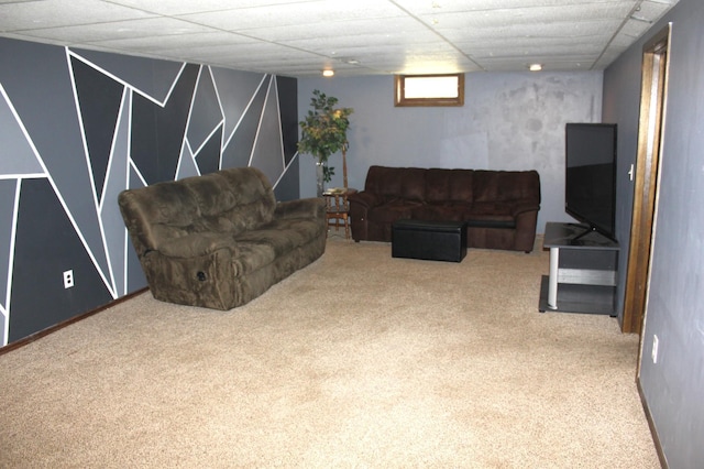 living room with a paneled ceiling and carpet