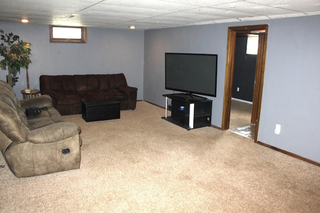 living room with baseboards, a paneled ceiling, and carpet