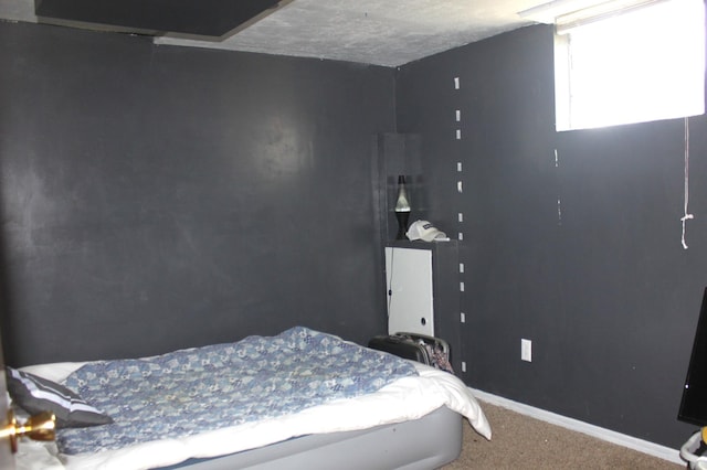 bedroom featuring a textured ceiling, baseboards, and carpet floors