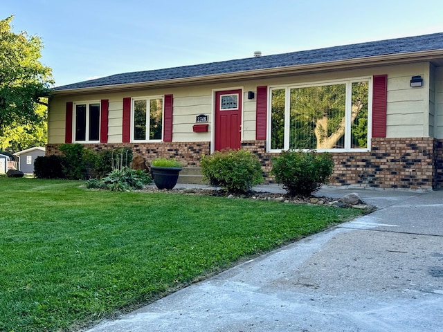 single story home featuring a front lawn and brick siding