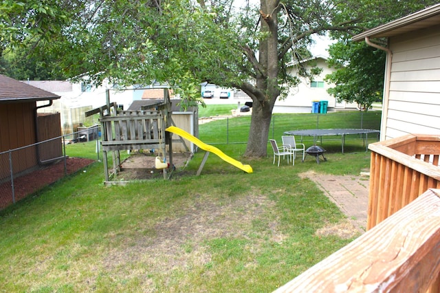 view of yard with a playground, a trampoline, and fence