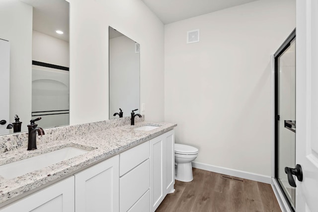 18746 Ivanhoe St NW, Elk River, MN 55330 - bathroom with wood finished floors, double vanity, and a stall shower