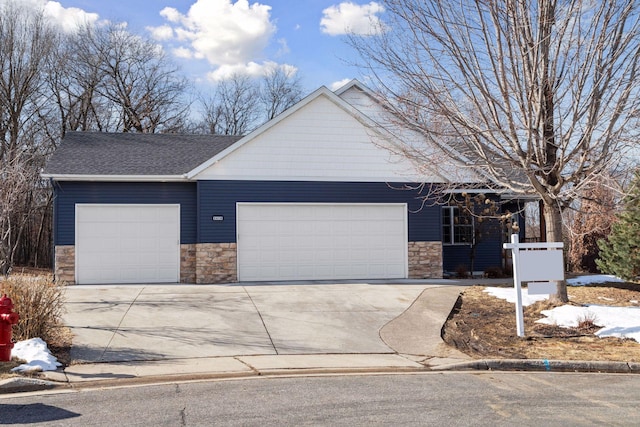 view of front of house featuring an attached garage, stone siding, driveway, and a shingled roof