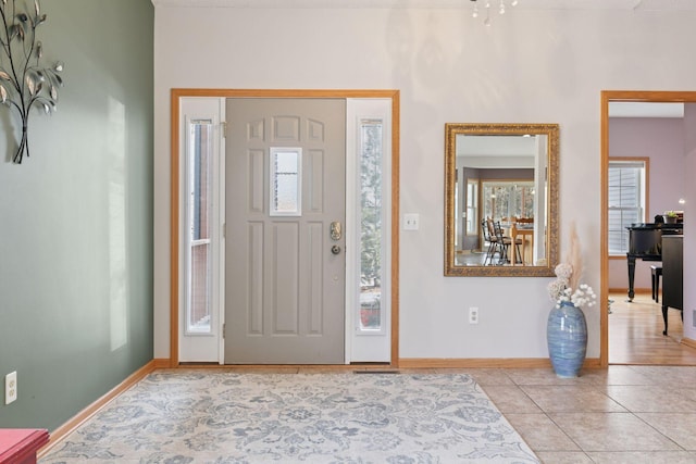 entrance foyer with light tile patterned floors and baseboards