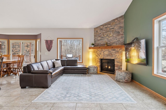 living room with plenty of natural light, a fireplace, and baseboards