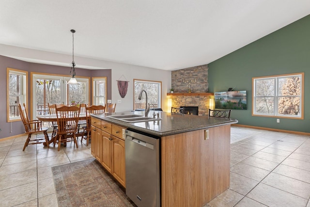 kitchen with dishwasher, a stone fireplace, plenty of natural light, and a sink