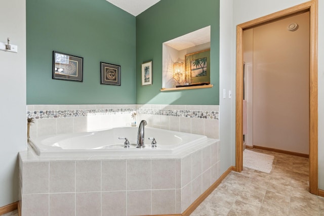 bathroom with tile patterned flooring, a bath, and baseboards