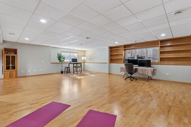 workout room with built in shelves, wood finished floors, visible vents, baseboards, and recessed lighting