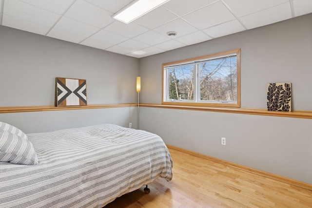 bedroom with visible vents, a paneled ceiling, and wood finished floors