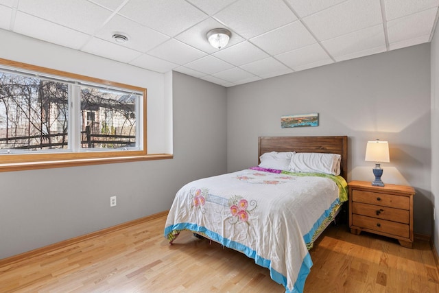 bedroom featuring a drop ceiling, visible vents, and wood finished floors