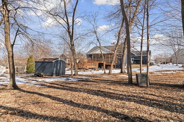 yard covered in snow featuring a storage unit and an outdoor structure