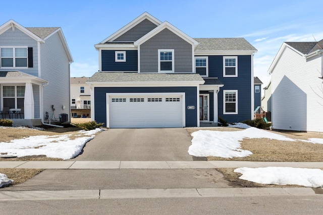 view of front of property with aphalt driveway, central air condition unit, a shingled roof, and a garage